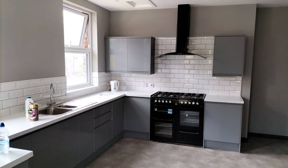 Kitchen with grey cupboards and white worktops